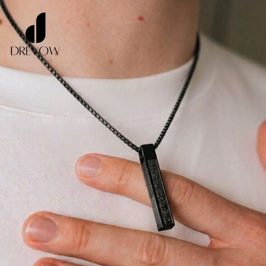 Person wearing a black necklace with a pendant, held by a hand against a white background.